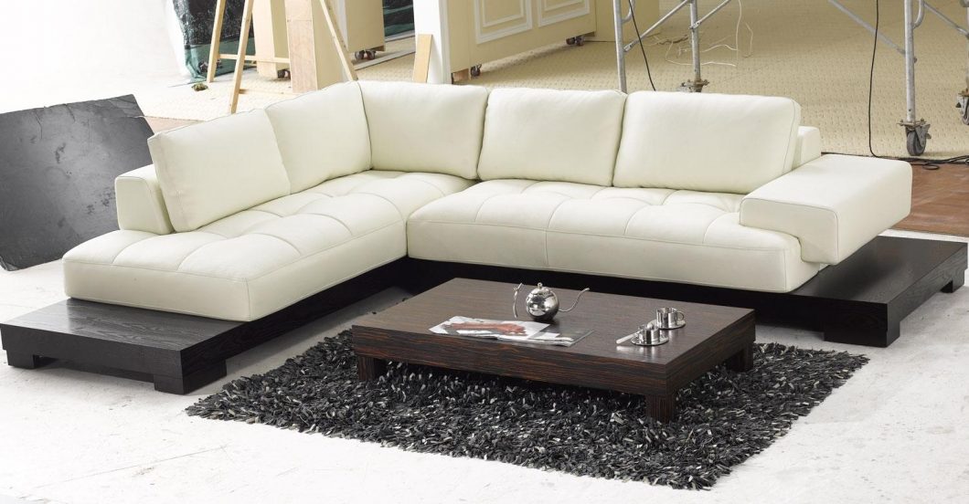 Furniture + Accessories Large-size Modern Leather Sectional White Sofa And Stained Wooden Table With Glass And Magazines Black Fur Rug White Floor Ideas And Several Furniture For Interior Home Furniture + Accessories