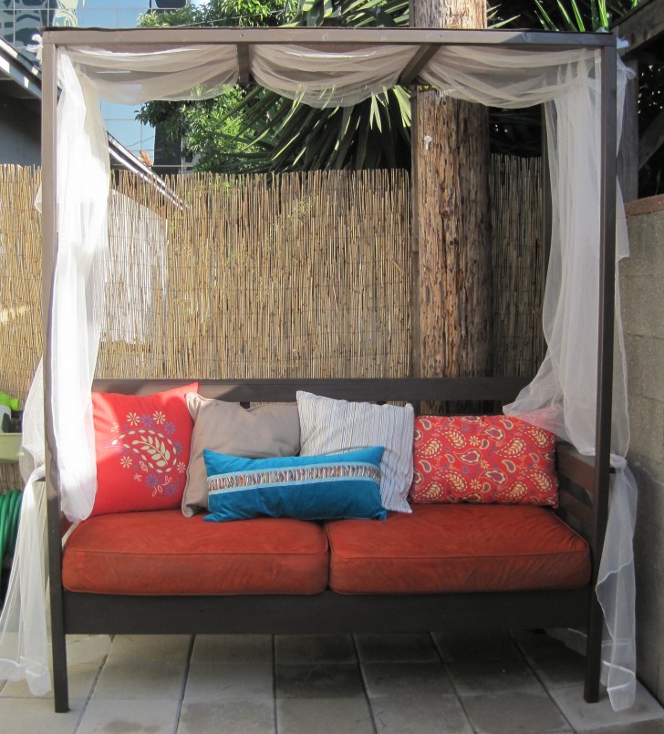 Red Puff As Well As Colorful Pattern Pillows Having Black Wooden Canopy As Well As White Valance On Grey Tiles Floor Fascinating Scheme Of Outdoor Daybed Escorted By Canopy Showing Modern Ideas